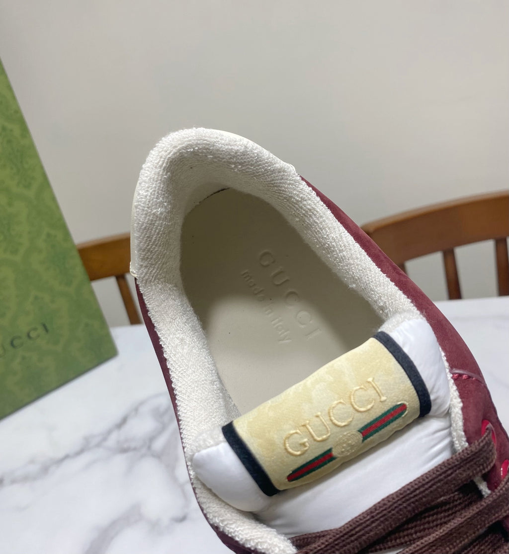 Gucci unisex sneaker tongue close-up with GG logo on white padded collar