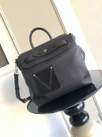 Men’s black leather top-handle bag with flap, strap, and front stitched emblem
