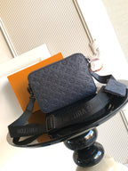 Crossbody bag in dark blue with monogram embossing, zipper closure, and shoulder strap