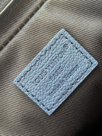 Blue leather crossbody bag patch with embossed logo and stitched edges
