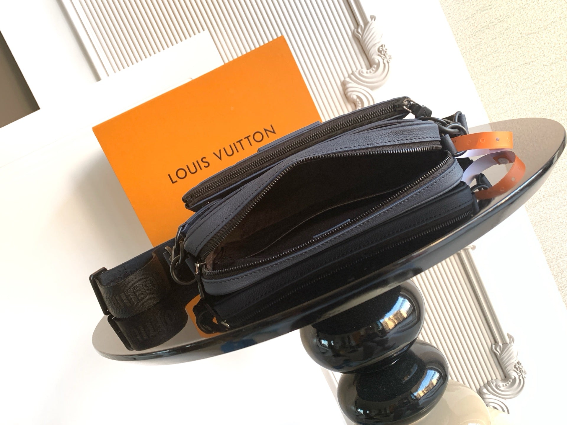 Dark blue crossbody bag with two zip compartments and monogram embossing