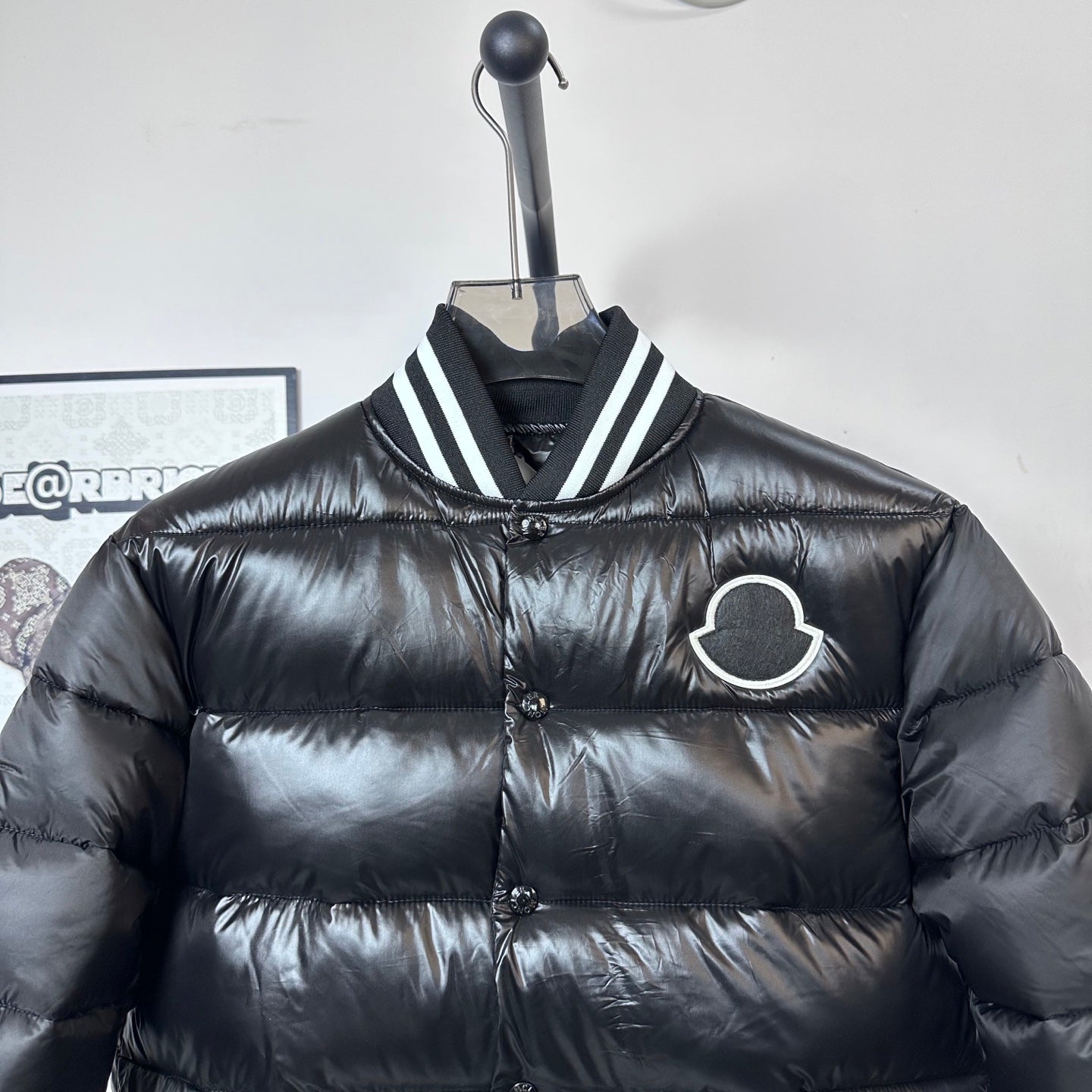 Moncler long puffer jacket, black, front close-up with striped collar and logo