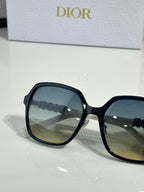 Dior sunglasses close-up with black oversized square frames and dark lenses