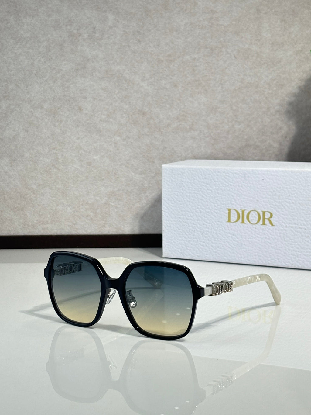 Dior sunglasses with teal-tinted frames and gradient lenses, silver-tone logo detail