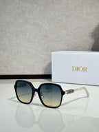 Dior sunglasses with teal-tinted frames and gradient lenses, silver-tone logo detail