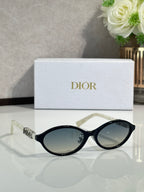 Dior sunglasses with black frame and oval dark lenses, front view.