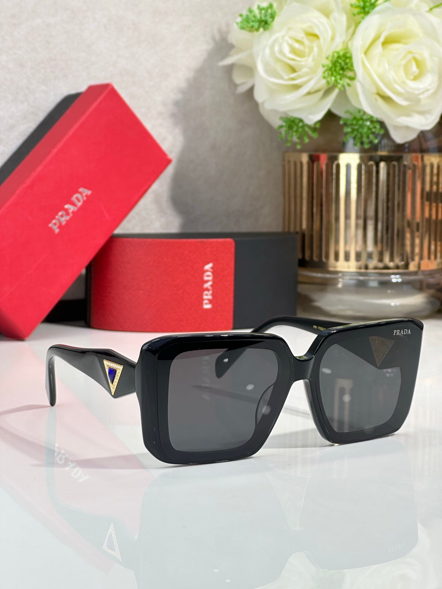 Black oversized square sunglasses with dark lenses and white temple tips