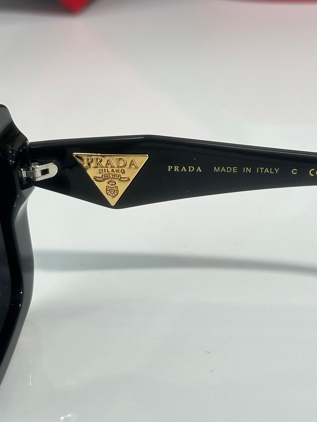 Black sunglasses temple detail with PRADA logo and MADE IN ITALY text