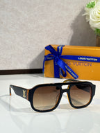 Black fashion sunglasses with brown gradient lenses and gold logo on temples