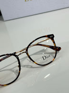 Dior eyeglasses close-up with tortoise round frames and clear lens, logo detail