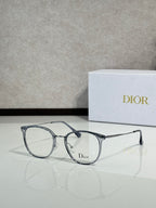 Dior eyeglasses with light blue-gray round frames and clear lenses, logo on bridge