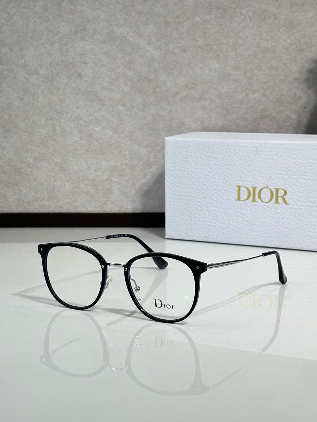 Dior eyeglasses with black round frames and clear lenses, metal logo detail