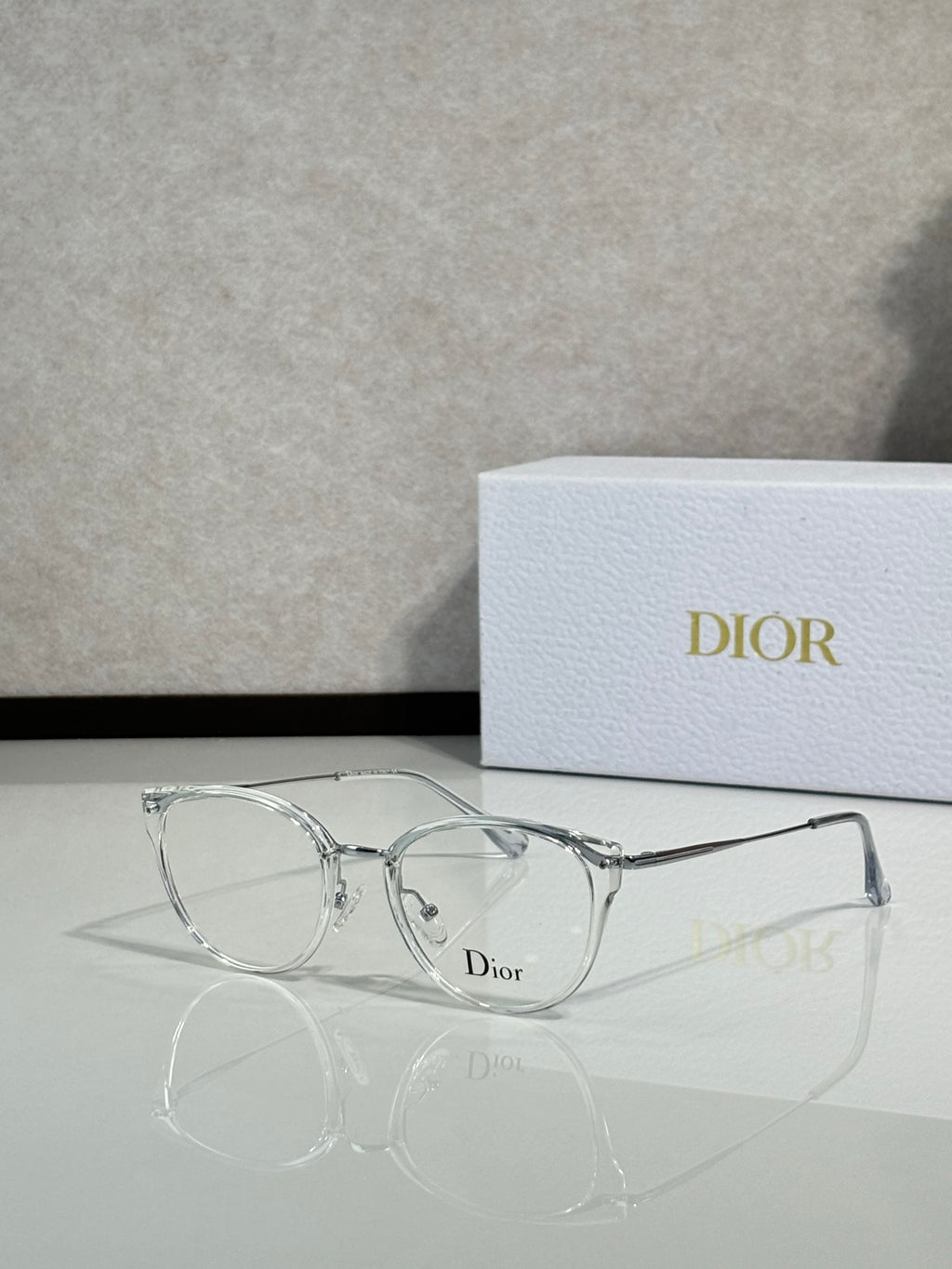 Clear metal round eyeglasses with silver-tone frame and Dior logo on lens