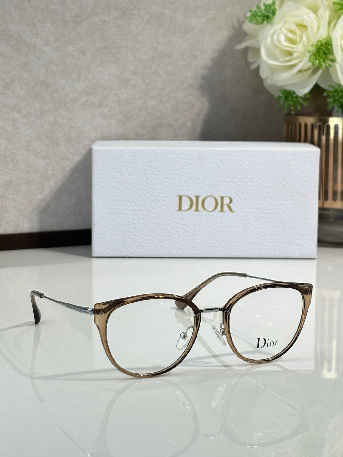 Light brown round eyeglasses with metal bridge and Dior logo on lens
