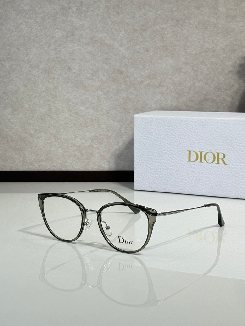 Smoke-tinted round eyeglasses with dark frame and Dior logo on lens