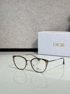 Gold-brown round eyeglasses with thin metal temples and Dior logo on lens