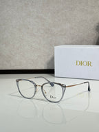 Silver round eyeglasses with gold-tone accents and Dior logo on lens