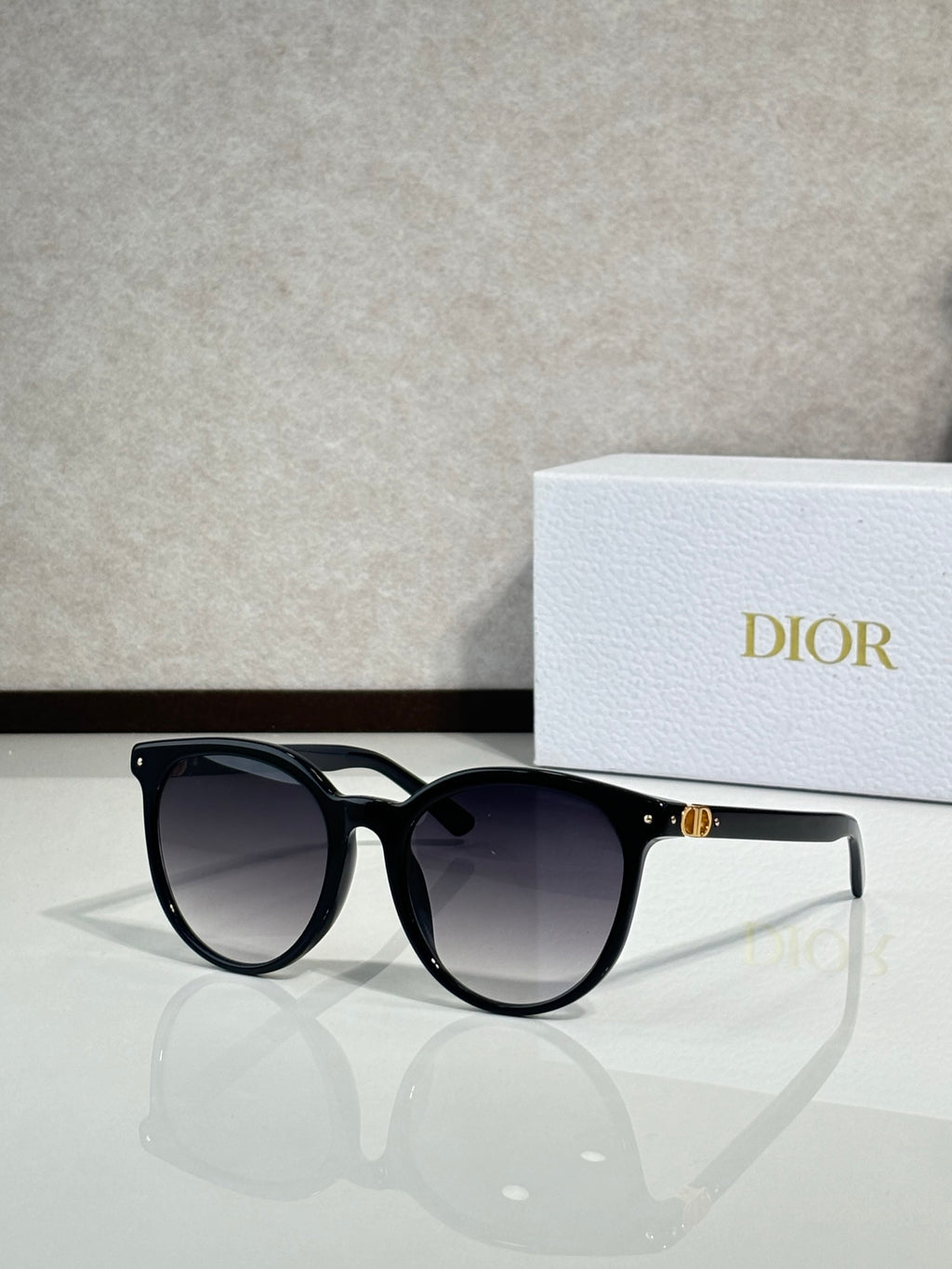 Sunglasses with black frame and dark lenses, rounded cat-eye shape