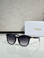 Sunglasses with black frame and dark lenses, rounded cat-eye shape