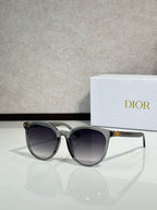 Sunglasses with translucent silver frame and dark lenses, rounded cat-eye shape
