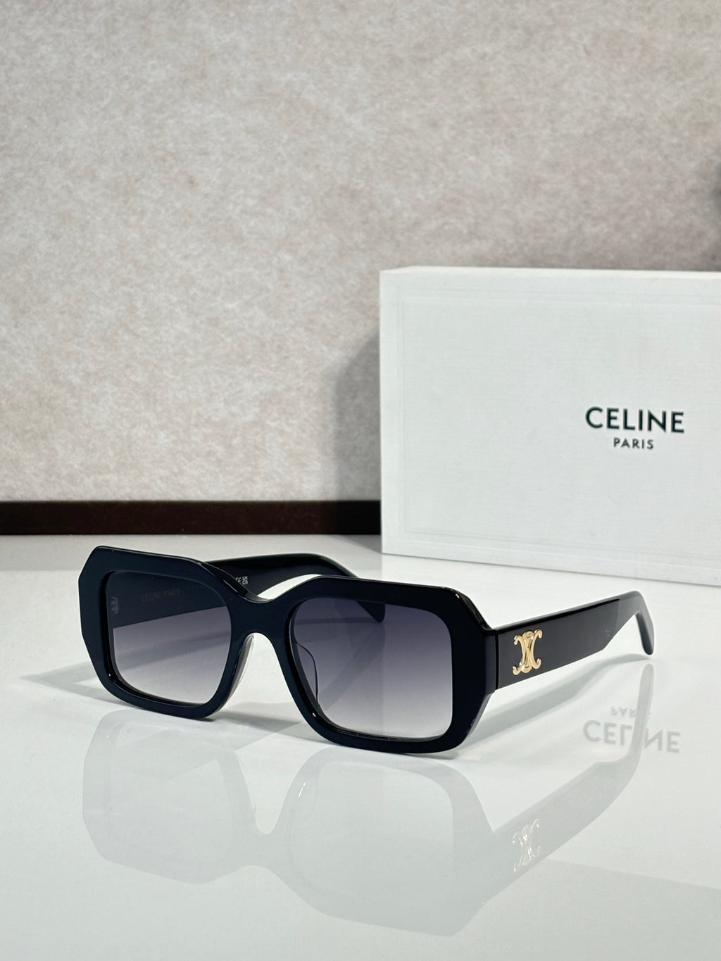 Celine black square sunglasses with gold logo on temple.