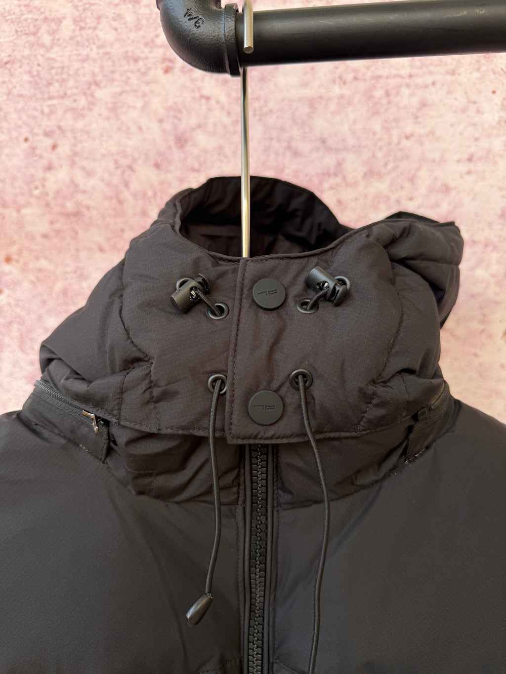 Dark gray hooded puffer jacket with full-zip front and drawcord hood ties