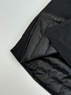 Black quilted interior lining of a long jacket, partially folded open