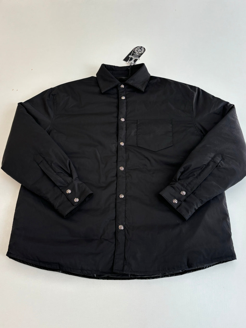 Black long-sleeve button-up jacket with pointed collar and chest pocket details