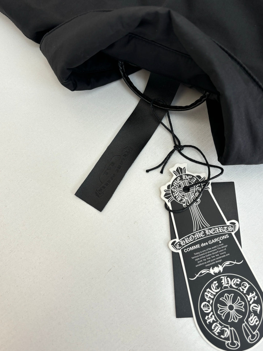 Black jacket tag and drawstring label attached to the garment