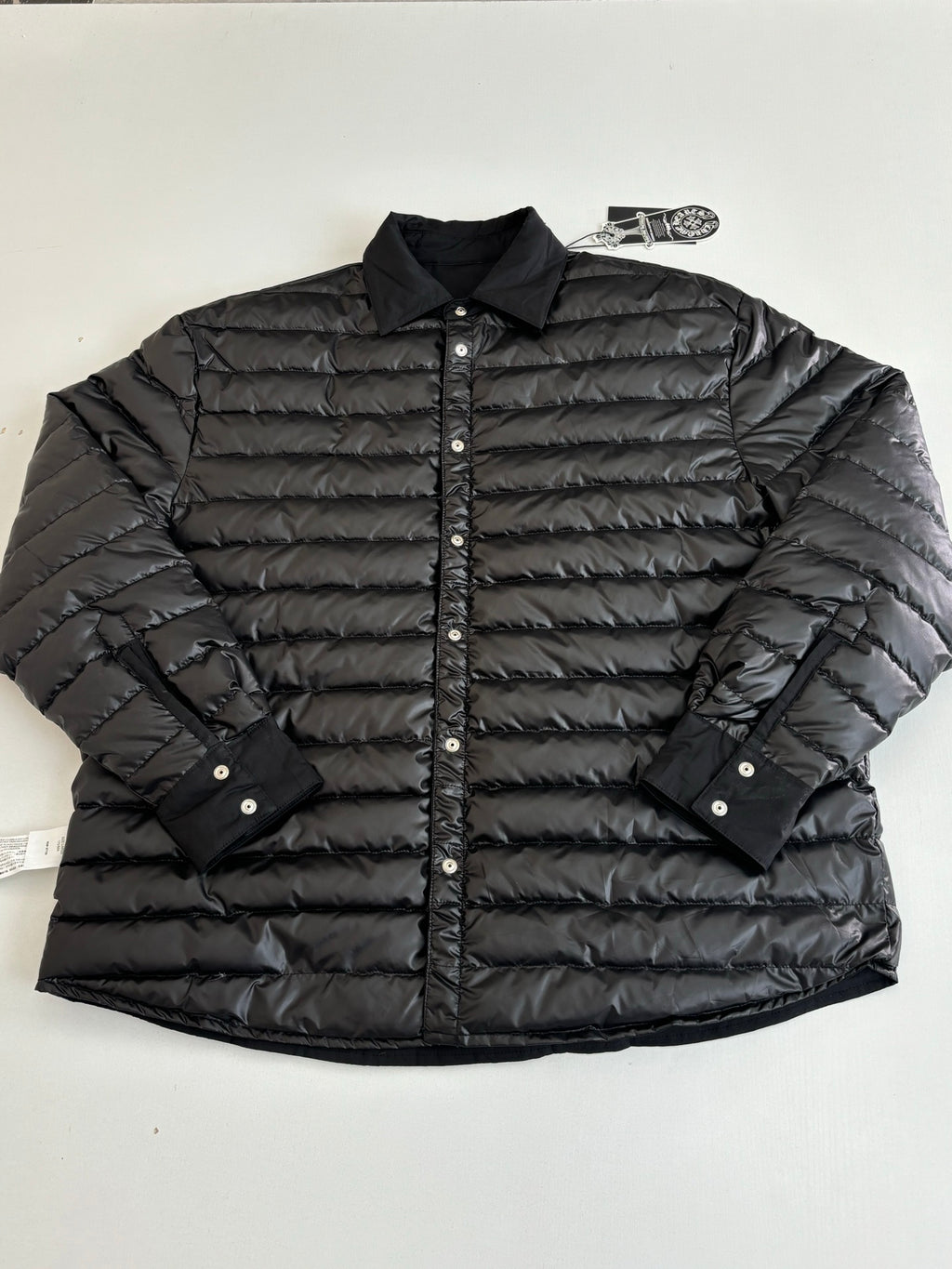 Black quilted puffer jacket with button placket and stand collar, long sleeves