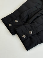 Black jacket sleeve cuffs and decorative button closures, laid flat