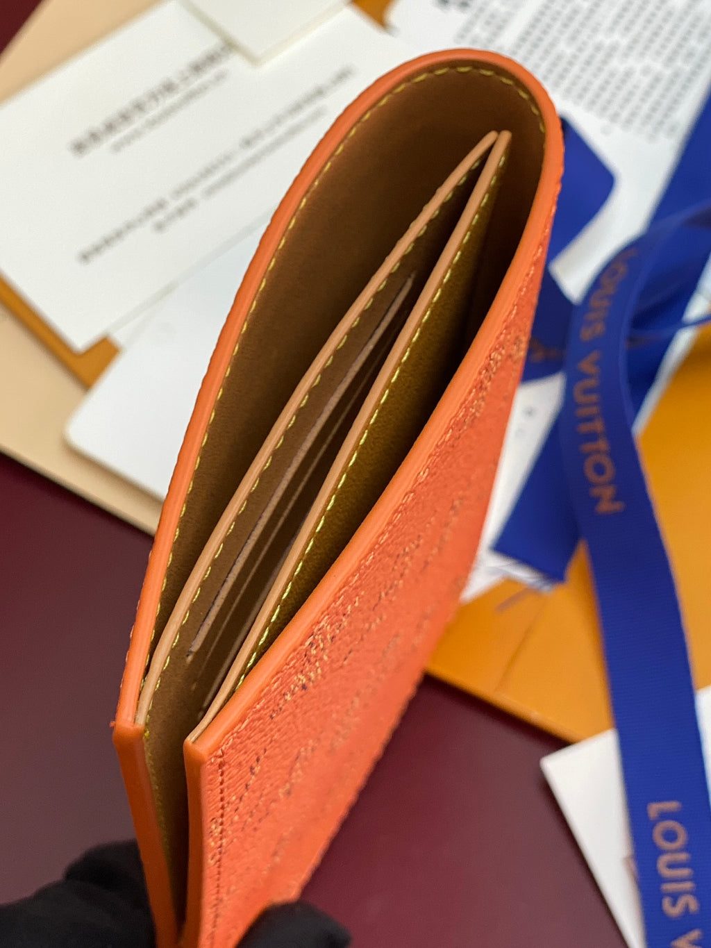 Louis Vuitton small bag, orange exterior with open brown-lined interior