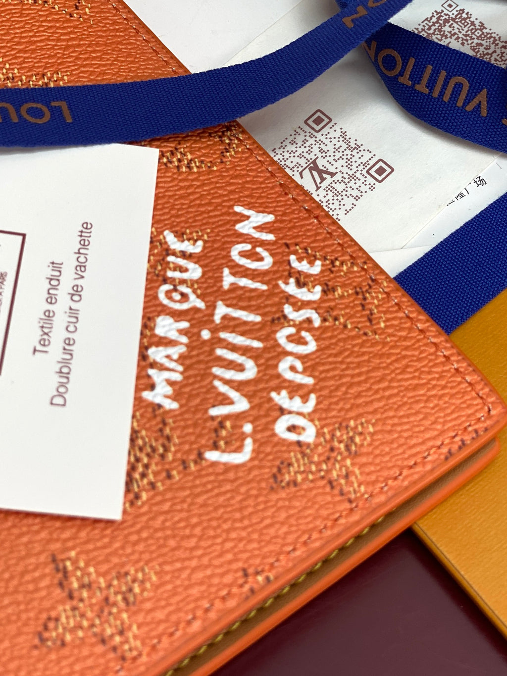 Small Louis Vuitton bag close-up of orange monogram embossing on leather