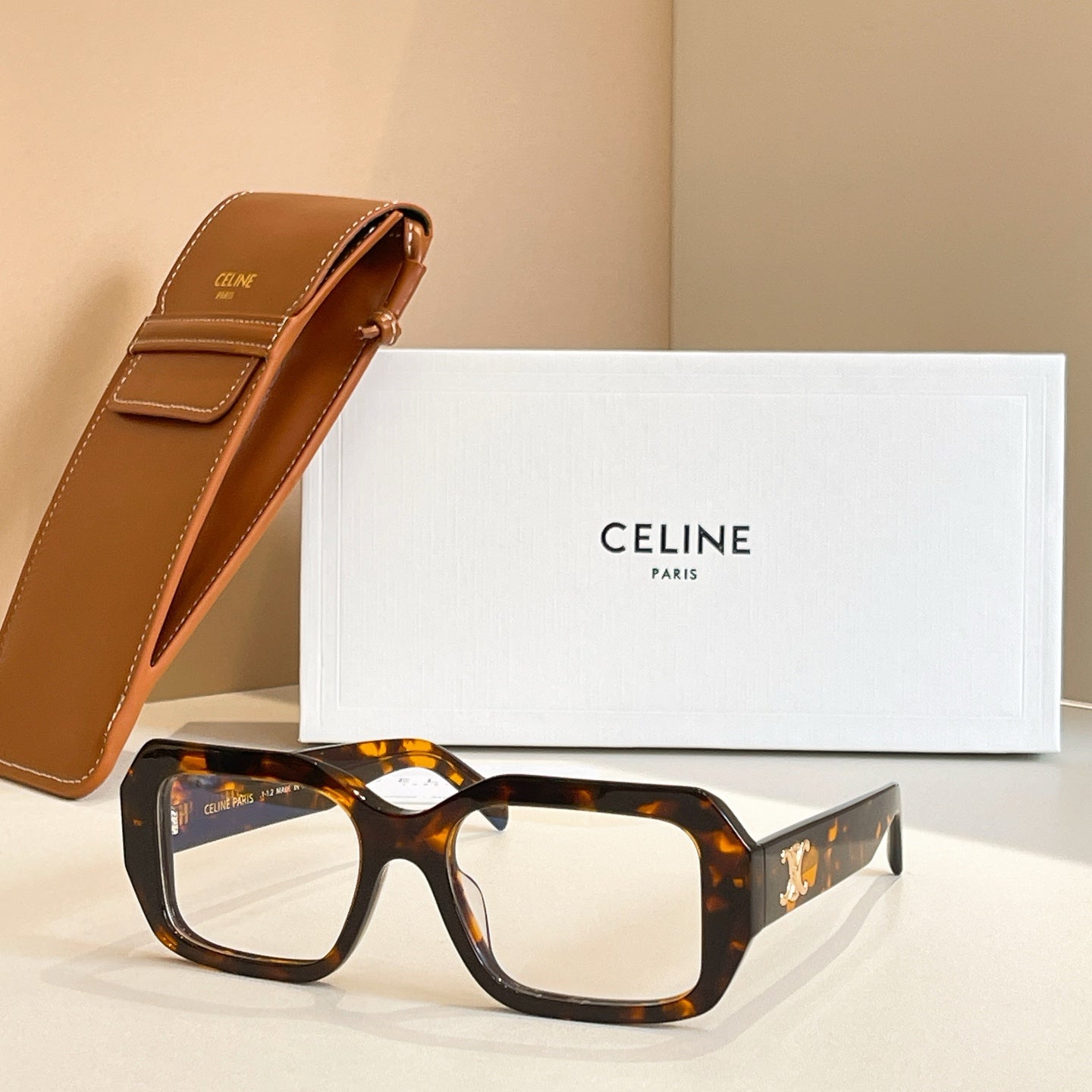 Tortoiseshell rectangular glasses with clear lenses and gold logo detail on temple