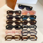 Stack of assorted glasses with black and tortoiseshell frames and gold logo temple details
