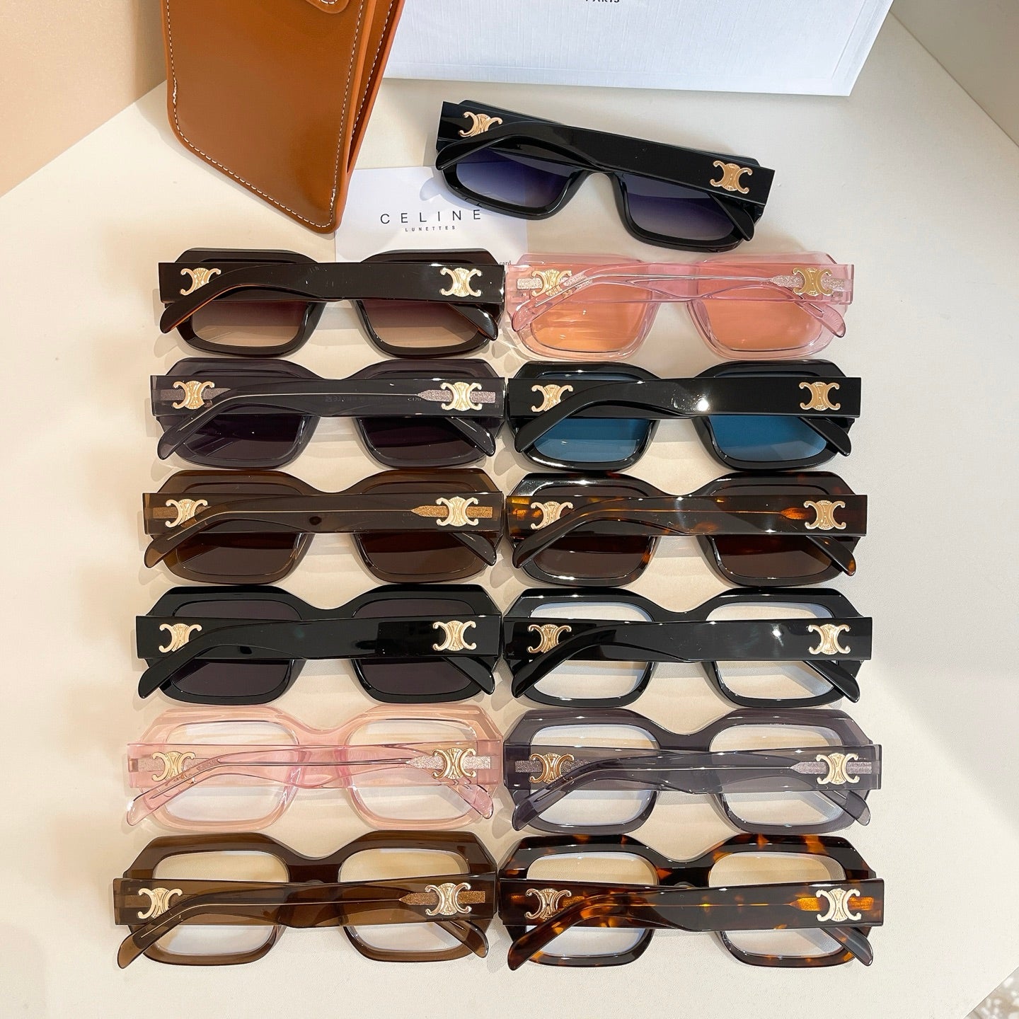 Stack of assorted glasses with black and tortoiseshell frames and gold logo temple details