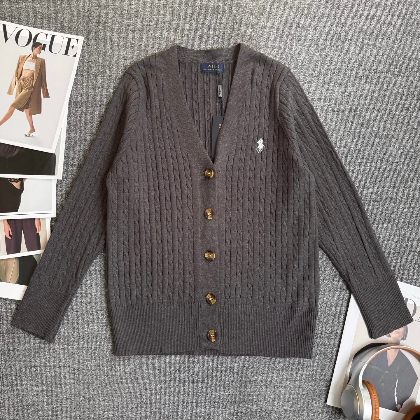 Dark gray cable-knit cardigan sweater with V-neck and gold button placket