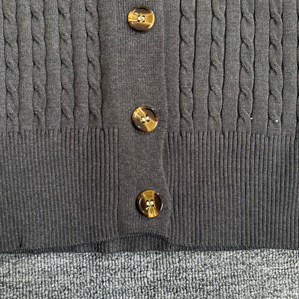 Dark gray cardigan front with gold-tone button closure