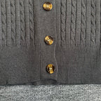 Dark gray cardigan front with gold-tone button closure