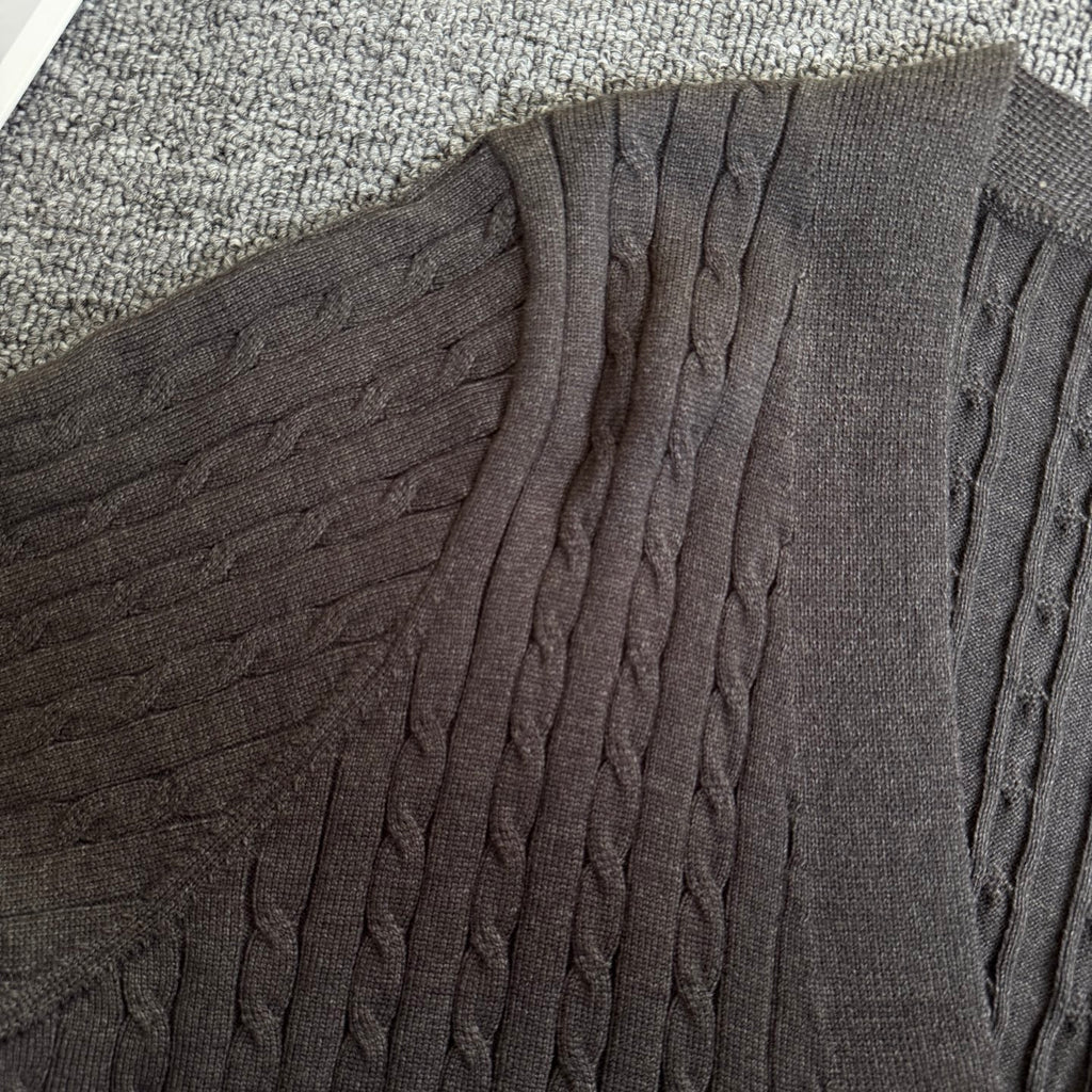 Dark gray cable-knit cardigan with textured vertical knit at shoulder and sleeve