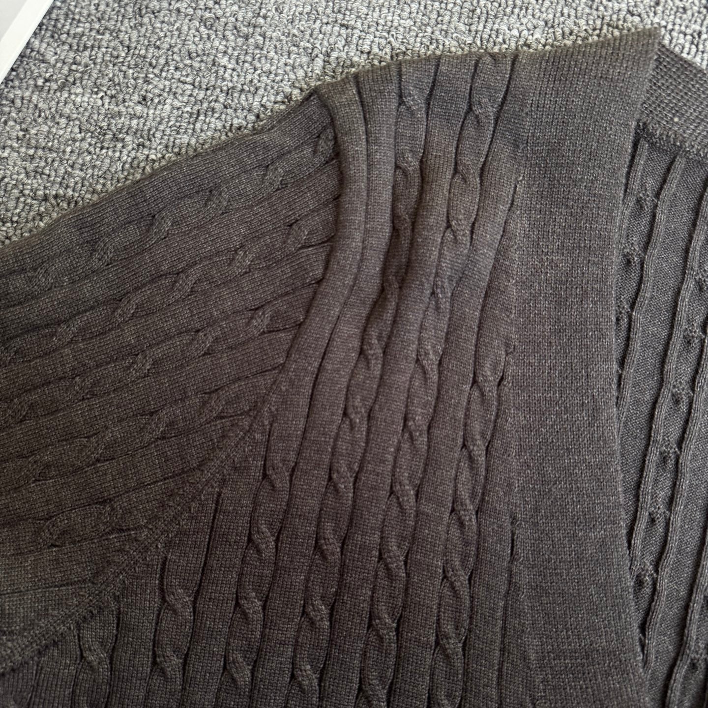 Dark gray cable-knit cardigan with textured vertical knit at shoulder and sleeve