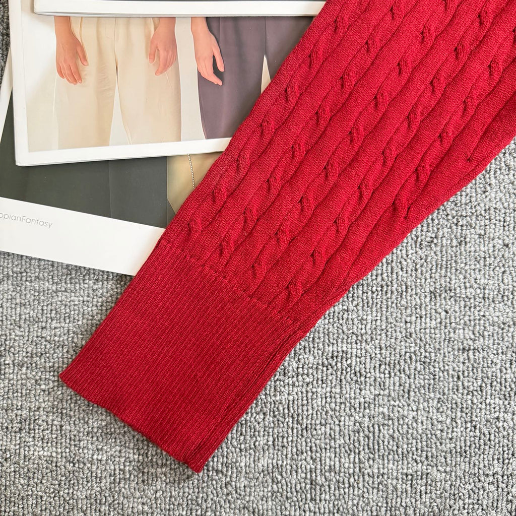 Red cable-knit cardigan sleeve and ribbed cuff with textured knit pattern