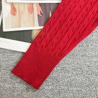 Red cable-knit cardigan sleeve and ribbed cuff with textured knit pattern