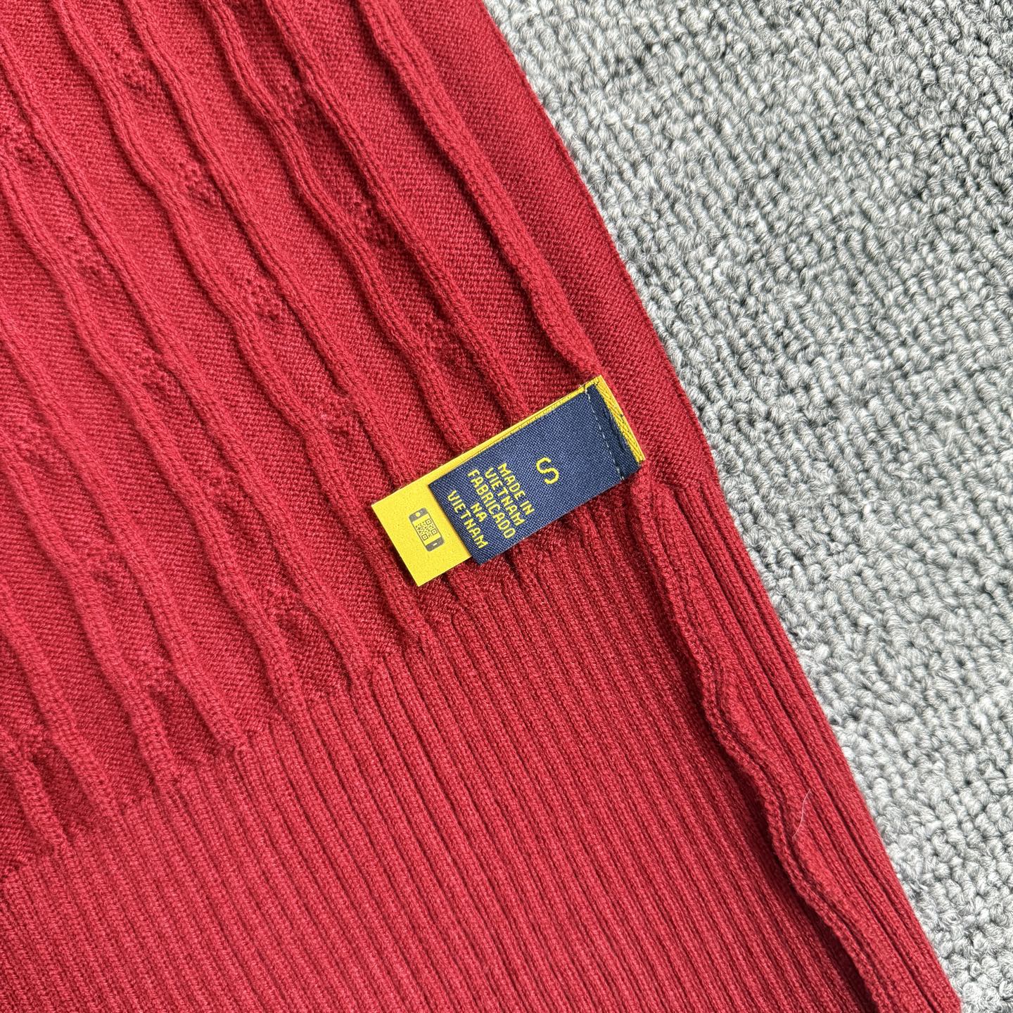 Red cable-knit cardigan inner neck label on sleeve