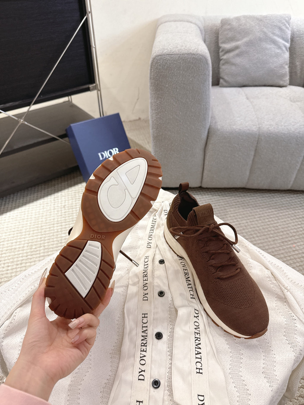 Dior unisex sneakers shown with outsoles visible: brown with white patterned tread