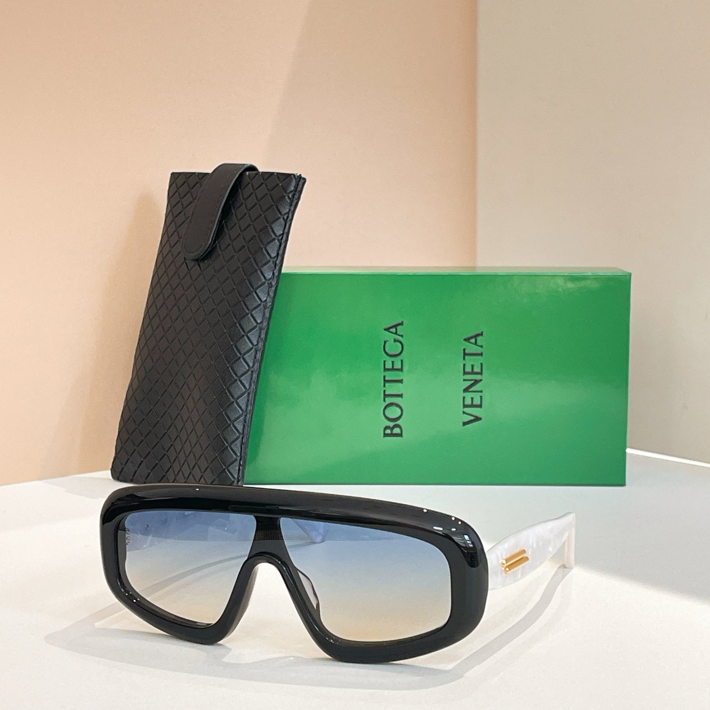 Bottega Veneta sunglasses with black frame and light blue-tinted lenses, black case