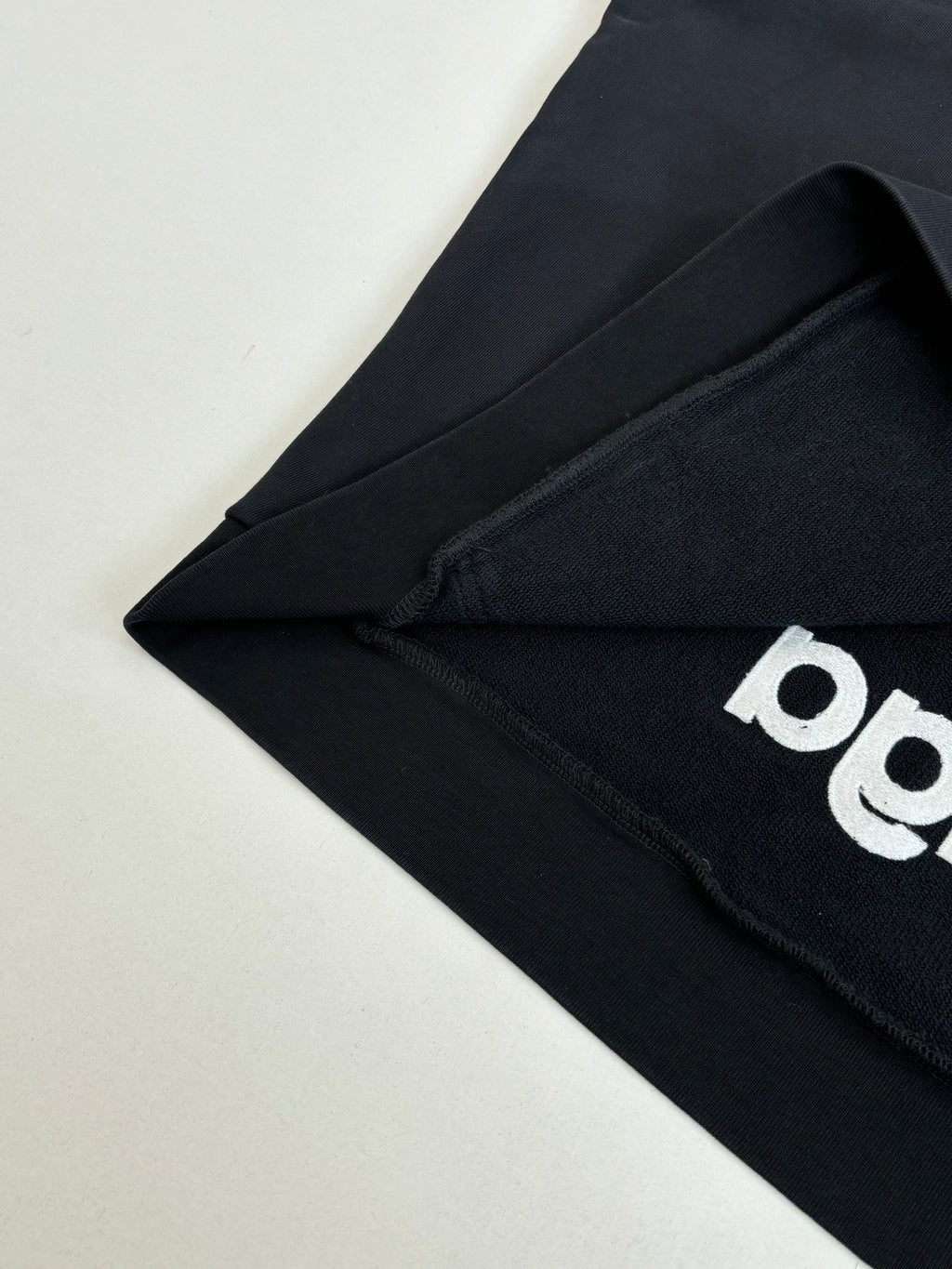 Balenciaga black hoodie fabric with partial white graphic logo detail