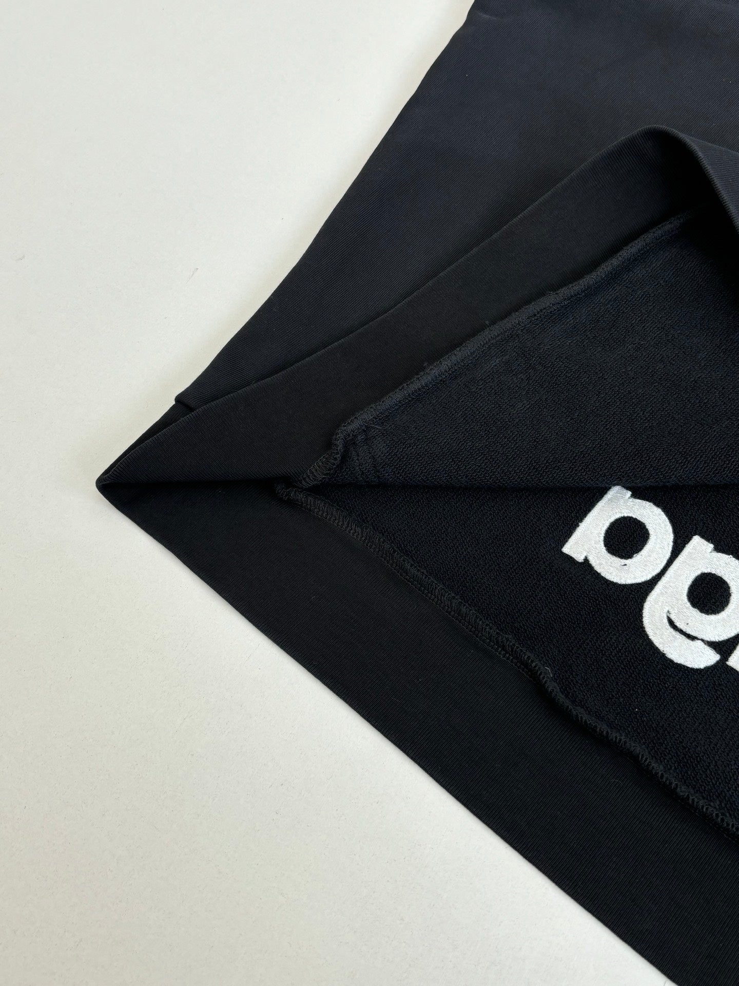 Balenciaga black hoodie fabric with partial white graphic logo detail