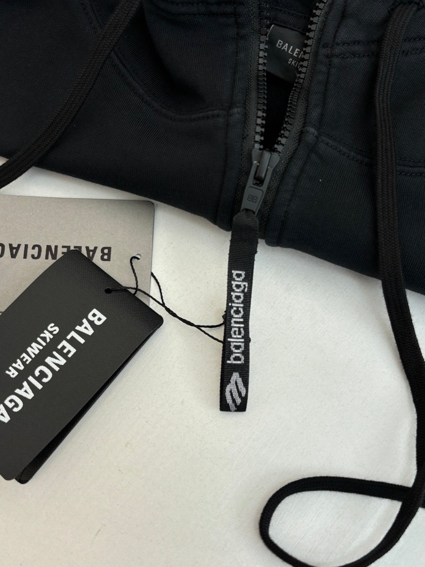 Balenciaga black hoodie zipper close-up with woven neck and logo tag