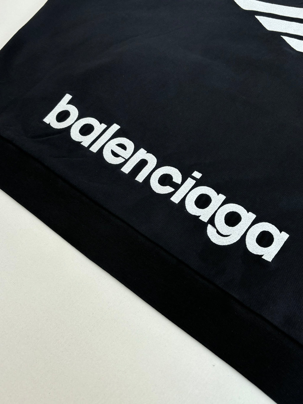 Balenciaga top with white 'balenciaga' logo lettering on black sleeve